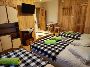 a room with two beds with green pillows on them at U Wajdy in Małe Ciche