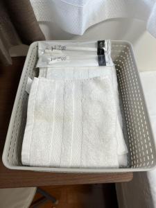 a metal container with white towels on a table at SkyHotel Kikukawa 駅徒歩2分 in Tokyo