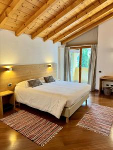 1 dormitorio con 1 cama grande y techo de madera en La Rosa Home, en Piuro