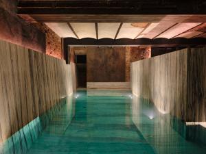 basen z wodą w budynku z zielonymi podłogami w obiekcie Grand Hotel w Łodzi
