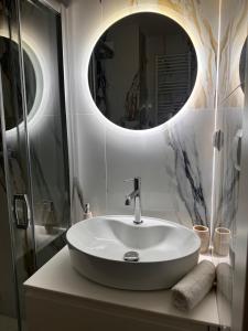 een badkamer met een witte wastafel en een spiegel bij Apartament N18 in Mrągowo