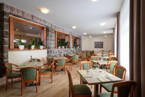 uma sala de jantar com mesas e cadeiras num restaurante em Horský hotel Remata em Ráztočno