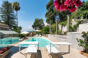 a pool with tables and chairs next to a house at Villa Voces in Catania +19 photos