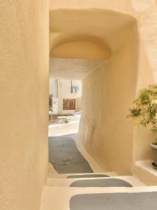 an alley way in a building with a potted plant at Camara’s Gem in Poros
