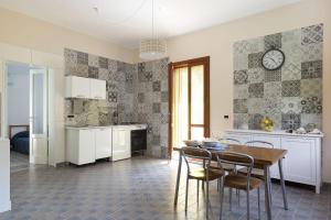 a kitchen with a table and chairs and a clock on the wall at Casa Spisone in Taormina +14 photos