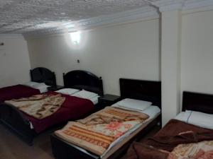 Zimmer mit 3 Betten in einem Zimmer in der Unterkunft Murree Continental Hotel in Murree