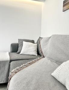 a gray couch with pillows in a living room at Camara’s Gem in Poros