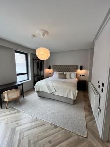 a bedroom with a large bed and a chandelier at The Glen Quarter in Kinsale