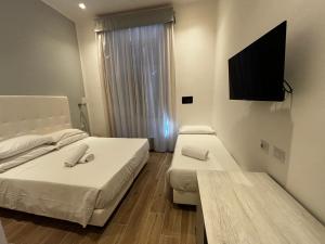 a hotel room with two beds and a flat screen tv at Hotel Gabriella in Rome