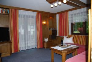 a living room with a couch and a tv at Apartmenthaus Maxl in Bad Hofgastein