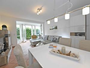eine Küche und ein Wohnzimmer mit einem weißen Tisch in der Unterkunft Haus "Concordia" in Binz - WG 02 "Seedorf" mit Terrasse, strandnah in Binz