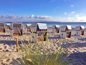 eine Reihe von Strandhütten an einem Sandstrand in der Unterkunft Haus "Concordia" in Binz - WG 02 "Seedorf" mit Terrasse, strandnah in Binz