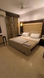 een slaapkamer met een groot bed met een groot hoofdeinde bij Metropolis Tourist Home Paharganj in New Delhi