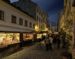 een groep mensen die 's nachts over straat lopen bij Continental Hotel-Pension in Wenen