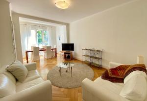 ein Wohnzimmer mit einem weißen Sofa und einem Tisch in der Unterkunft Very nice apartment close to the lake in Lausanne