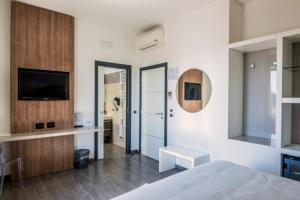 uma sala com um quarto com uma cama e uma televisão em Motel S.16 em Muro Leccese