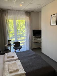 クリニツァ・ズドルイにあるAmphora Kompleks Wypoczynkowyのベッドルーム1室(ベッド1台、デスク、窓付)