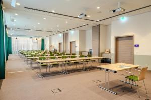 a room with rows of tables and chairs at IntercityHotel Lübeck in Lübeck
