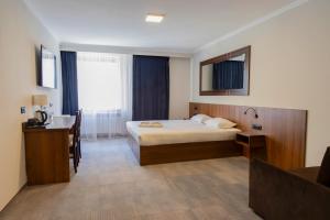 una camera d'albergo con letto, tavolo e scrivania di Hit Hotel a Varsavia