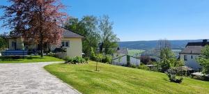 ein Haus mit einem Rasenplatz mit Auffahrt in der Unterkunft Ferienwohnung Bergidyll in Schwarzenberg/Erzgebirge