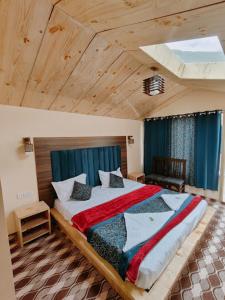 a bedroom with a large bed with a wooden ceiling at The Grand Lodge Pangong in Lukung