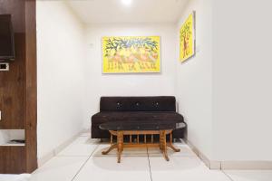 a black chair and a table in a room at Hotel Shree Ram Palace in Indore