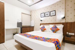 a bedroom with a large bed in a room at FabHotel Shree Ram Palace in Indore +20 photos