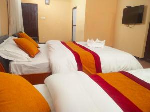 - une chambre d'hôtel avec 2 lits et des couvertures colorées dans l'établissement Kathmandu Fawlty Home, à Katmandou
