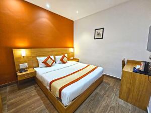 Hotel The Bundela - Khajuraho, Madhya Pradesh في خاجوراهو: غرفة نوم بسرير كبير في غرفة الفندق