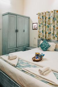 1 dormitorio con 2 camas, toallas y una cesta en la cama en Safarnama Varanasi A Boutique B&B, en Varanasi
