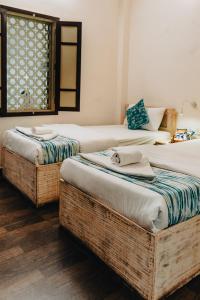 a bedroom with two beds with wicker baskets at Safarnama Varanasi A Boutique B&B in Varanasi