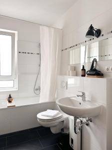 a white bathroom with a sink and a toilet at NOOK Design Apartments with Kitchen in Berlin