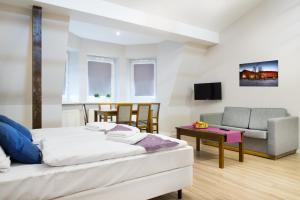 a bedroom with a bed and a couch and a chair at Emaus Apartments in Kraków