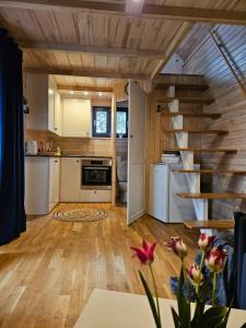 eine Küche mit einer Treppe in einem winzigen Haus in der Unterkunft Domek na korcie in Lubomierz