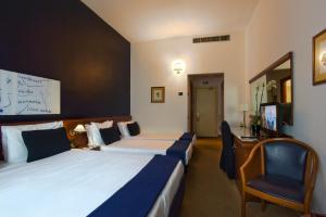 Pokój hotelowy z 2 łóżkami i krzesłem w obiekcie Grand Hotel Tiberio w Rzymie