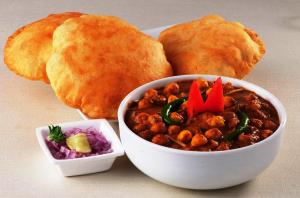 a bowl of chili and a plate of bread at FabHotel Shree Ram Palace in Indore