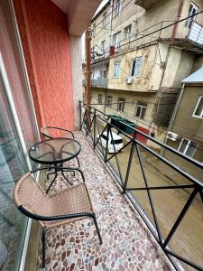 un balcón con mesa y sillas y un edificio en Qeroli old town, en Tiflis