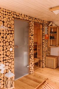 an open door in a room with a wall of logs at Dzikowiejsko in Bardo