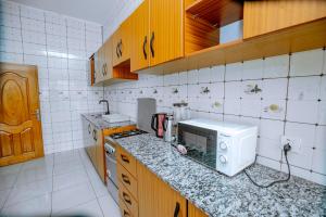 een keuken met een aanrecht met een magnetron bij Kigali Wings Apartment 4 in Kigali +14 foto's
