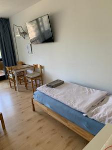 Panoramahaus App 4086 في باد رايشنهال: غرفة نوم مع سرير وغرفة طعام مع طاولة