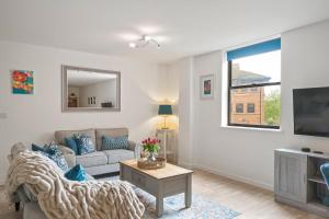 ein Wohnzimmer mit einem Sofa und einem TV in der Unterkunft Modern Apartment Private Parking Central Taunton in Taunton