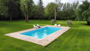 - une piscine au milieu d'une cour dans l'établissement chalet paradisiaque en bord de Marne Proche de Disneyland, à Isles-lès-Villenoy