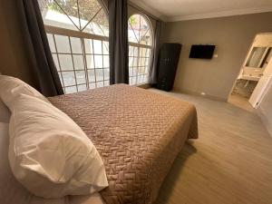 een slaapkamer met een bed en een groot raam bij Villa Sicilia in Guatemala