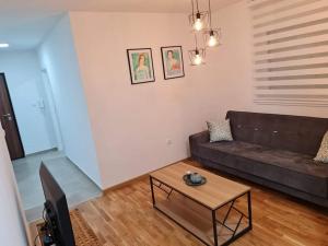 a living room with a couch and a coffee table at Apartman Mirabell, Doboj in Doboj