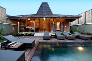 a backyard with a swimming pool and a house at The Lakshmi Villas by The Beach House in Gili Trawangan