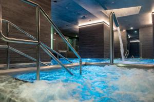 a hot tub with blue water in a building at Grandhotel Pupp in Karlovy Vary