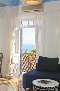 un soggiorno con divano blu e vista sull'oceano di cherry's home a Glossa