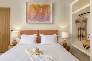una camera da letto con un letto con un cappello sopra di Teresa Spetses a Spetses