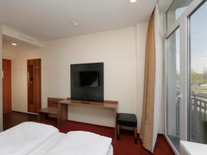 B&B HOTEL Berlin-Adlershof في برلين: غرفه فندقيه سريرين وتلفزيون