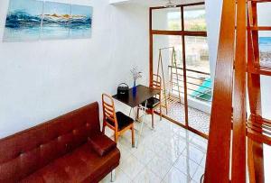a living room with a couch and a table at The Lavana Villa Del Matabungkay by RedDoorz in Lian